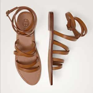 Tan flat Roman sandals.